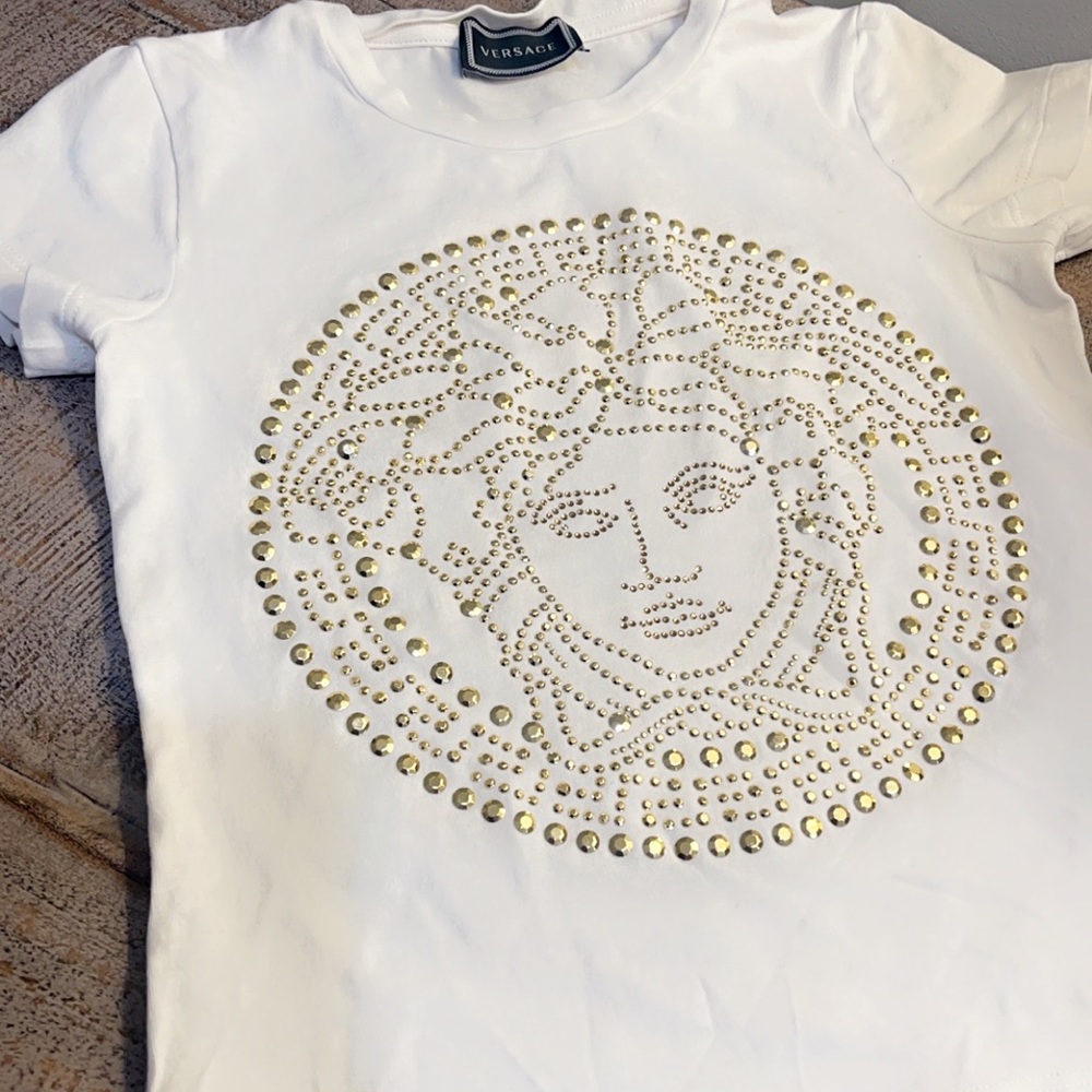 Cream and gold Versace children’s 4T shirt. Small dot stain left upper